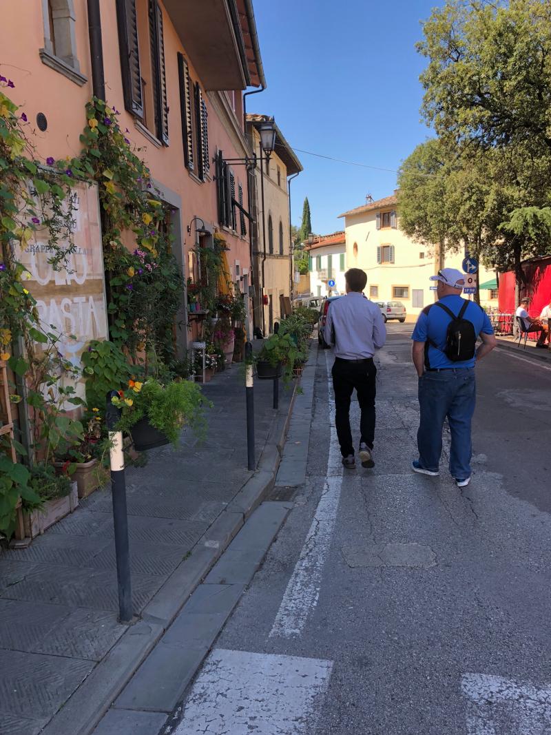 Walking through a European neighborhood in practical casual travel clothing