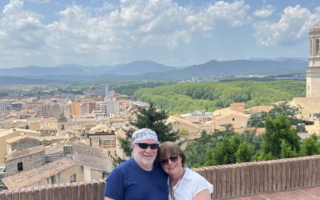 Couple overlooking Girona, Spain while exploring Europe through strategic travel planning and points and miles.