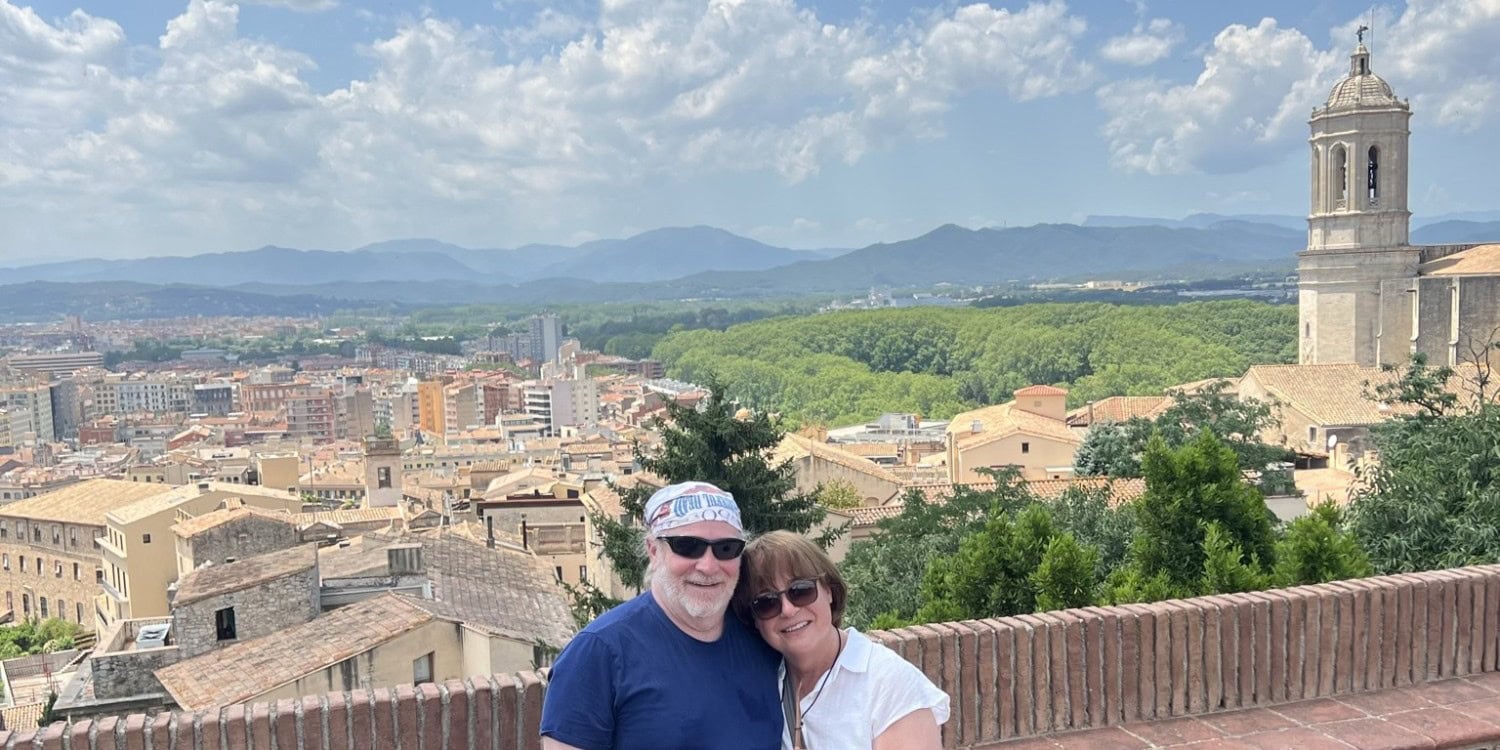 Couple overlooking Girona, Spain while exploring Europe through strategic travel planning and points and miles.