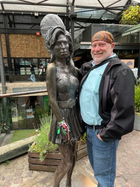Traveler posing beside the Amy Winehouse statue at Camden Market in London, England