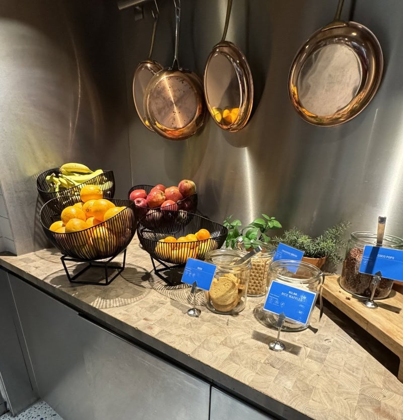 Airport lounge food and beverage area with fresh fruit and snacks available to travelers before departure.