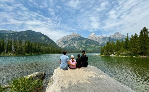 Family enjoying a scenic lake and mountain view in Grand Teton National Park near Jackson Hole, Wyoming.