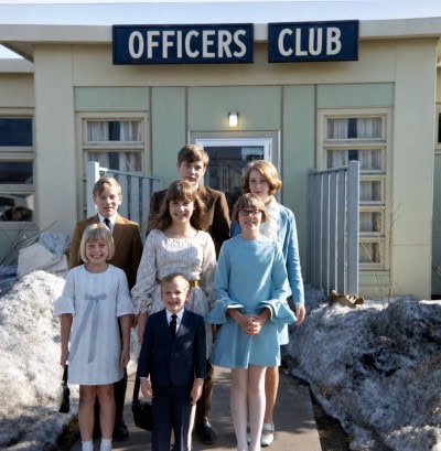Seven Shipley siblings as children standing outside an Officers Club during their family's overseas military years.