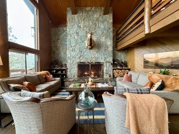 The elegant great room and stone fireplace inside the main lodge at RiverView Ranch Retreat & Western Adventures in Montana, a luxury all-inclusive guest ranch bookable with Hilton Honors points.