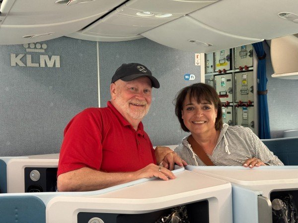 Randy and Leslie smiling in their KLM business class seats