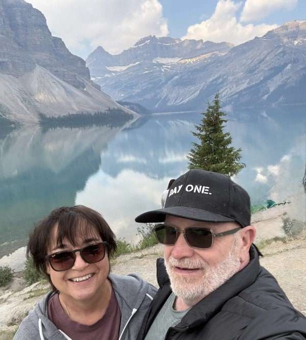 Couple beside Bow Lake with mountain reflections in Banff National Park