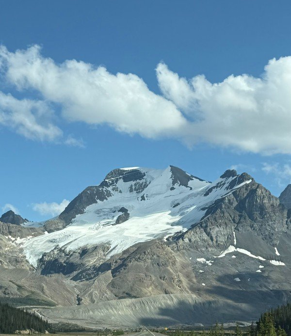 Glacier-covered mountain beneath blue skies along the Icefields Parkway
