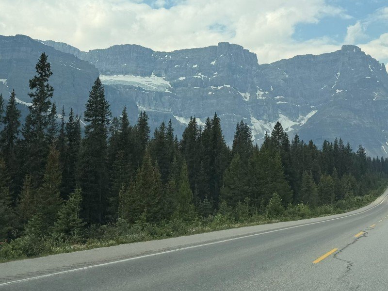 Icefields Parkway road beneath mountains and glaciers in Banff National Park
