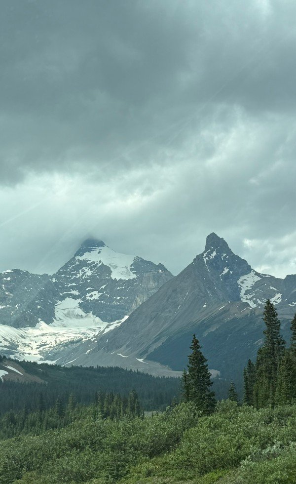 Dark storm clouds over glacier-covered mountains along the Icefields Parkway