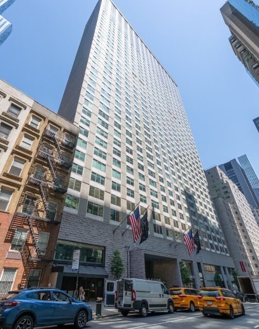 Thompson Central Park New York hotel exterior viewed from street level on a sunny day.