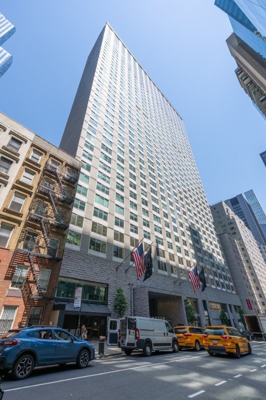 Thompson Central Park New York hotel exterior viewed from street level on a sunny day.